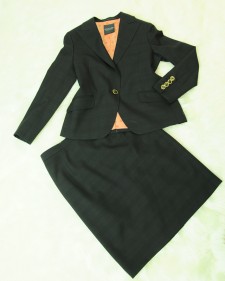 ブラックチェックの織柄のスカートスーツに個性を出したオレンジ色裏地使い<br />Black skirt suit, with unique orange lining.